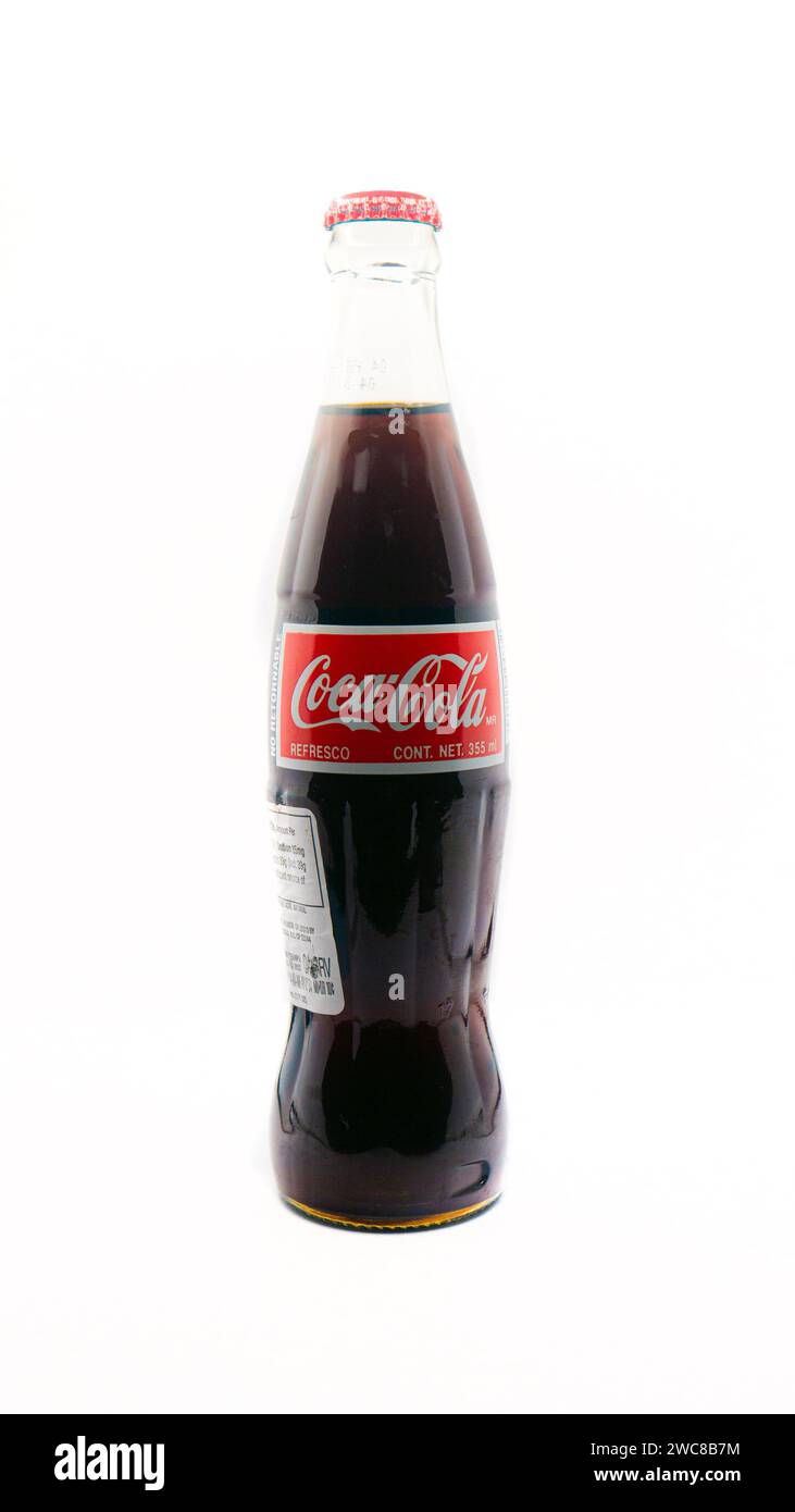 Importierte mexikanische Coca-Cola-Flasche isoliert auf weißem Hintergrund mit zusätzlichem Etikett für den Import hinzugefügt Stockfoto