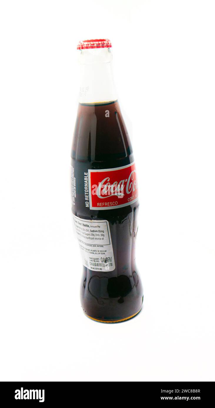 Importierte mexikanische Coca-Cola-Flasche isoliert auf weißem Hintergrund mit zusätzlichem Etikett für den Import hinzugefügt Stockfoto