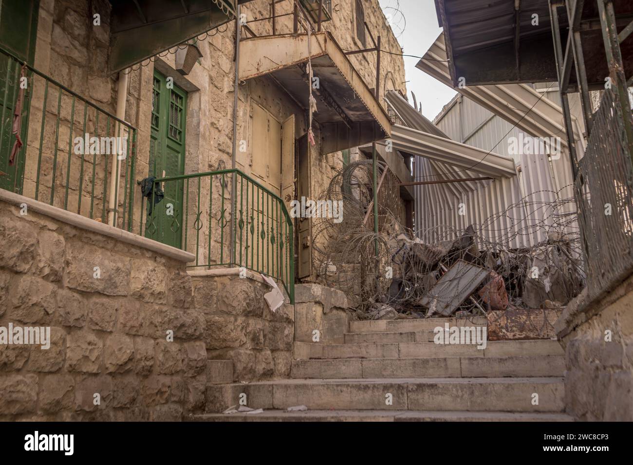 Der Stacheldraht und die blockierte Passage an der Grenze zwischen israelisch kontrollierten und von Palästina kontrollierten Gebieten Hebrons im palästinensischen Westjordanland. Stockfoto
