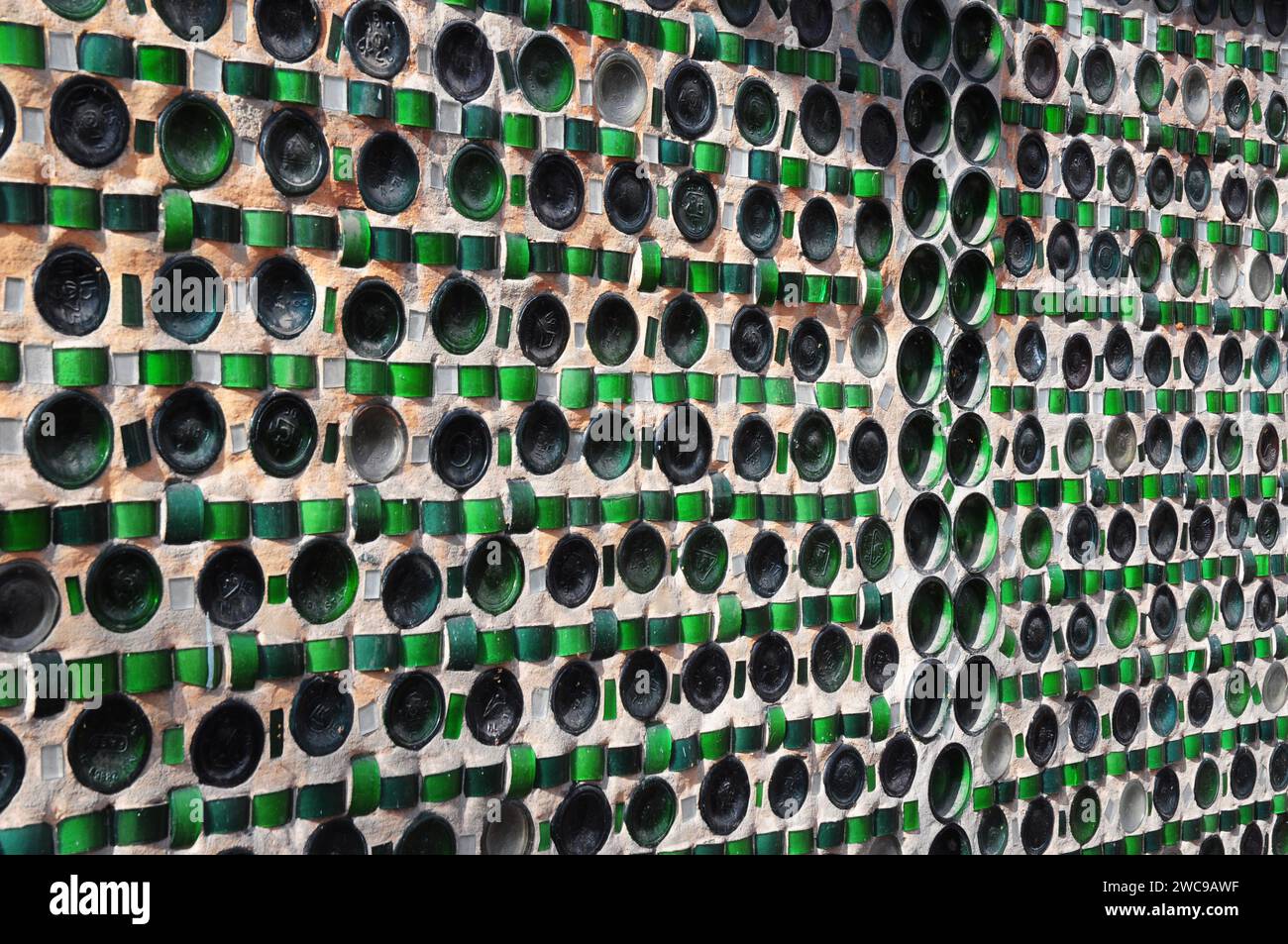 Eine Glasflaschenwand eines farbigen Flaschengebäudes aus umweltfreundlichen, Upcycling-Baumaterialien Glasflaschen und Stockfoto