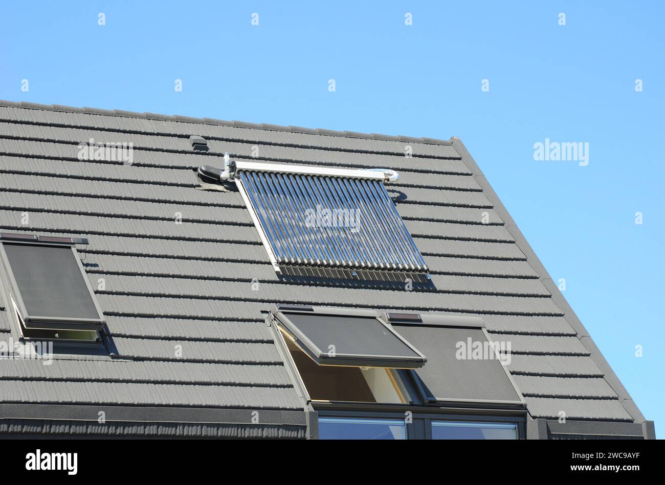 Modernes Haus auf der Dachterrasse mit Dachfenster im Mansardengeschoss und solarer Wasserheizung Stockfoto