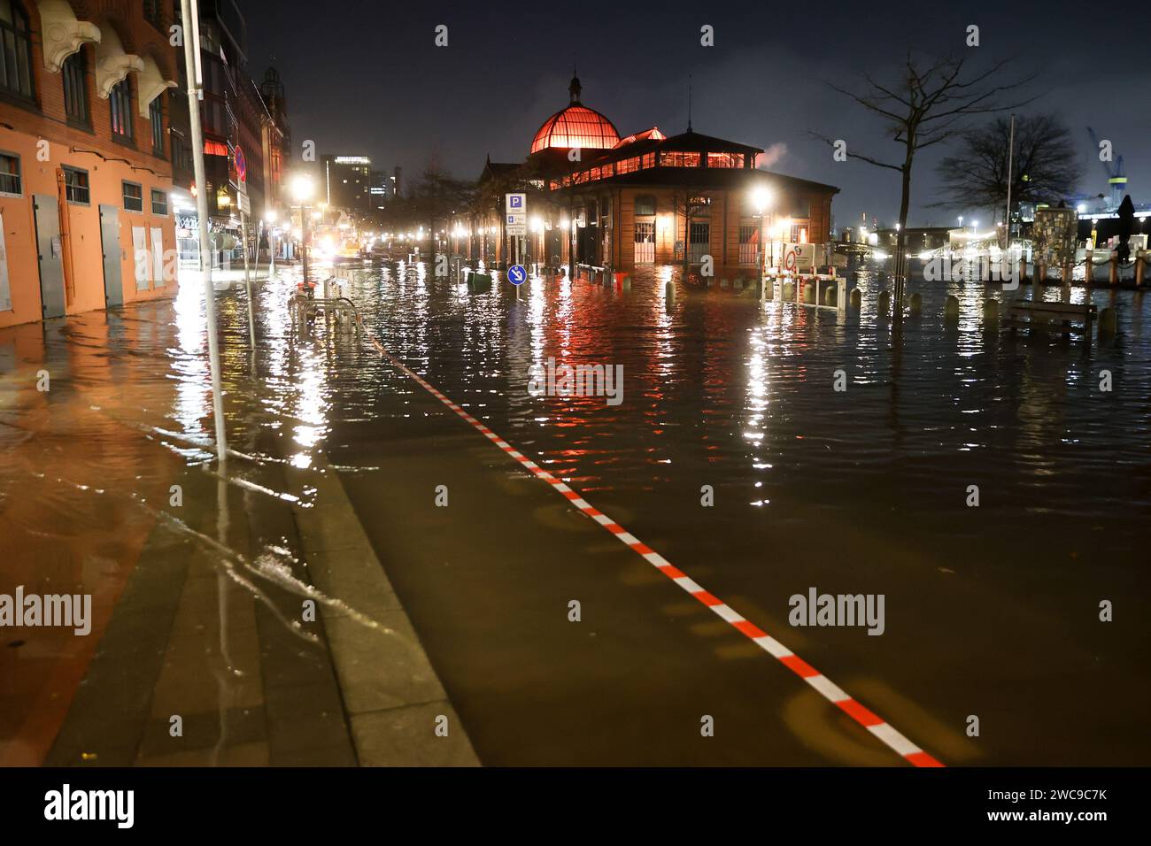 Hamburg, Deutschland. Januar 2024. Das Elbwasser wird während einer Sturmflut auf die große Elbstraße am Hamburger Fischmarkt gedrückt. Am Montagmorgen hat die Sturmflut erneut viel Wasser an die Nordseeküste und in Elbe und Weser geschoben. In Hamburg waren der Fischmarkt und die große Elbstraße vollständig unter Wasser. Nach Angaben des Bundesamtes für Seeschifffahrt und Hydrographie (BSH) ist das Wasser am St. Die Pauli-Spurweite war kurz vor 7,00 Uhr auf etwa 2,30 Meter über dem mittleren Hochwasser angestiegen. Quelle: Bodo Marks/dpa/Alamy Live News Stockfoto