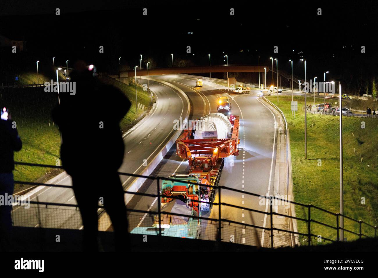 Hirwaun Power, Drax, transportierte ein 700 Tonnen schweres Lastkraftfahrzeug zusammen mit einer Polizeieskorte auf der A456 in der Nähe von Llanelli Hill als Teil der Arbeiten zum Bau eines neuen Gaskraftwerks, des Kraftwerks, das einmal in Betrieb war, kann bis zu 1.500 Stunden in einem beliebigen Jahr laufen. Sie wird als Reserve für andere Stromquellen dienen, darunter wetterabhängige Windturbinen und Solarparks, Llanelli Hill, Vereinigtes Königreich, 15. Januar 2024 Link to Hirwaun Power; https://www.drax.com/about-us/our-projects/hirwaun-power/#frequently-asked-questions-faqs (Foto: Thomas Winstone/News Images) in Llan Stockfoto