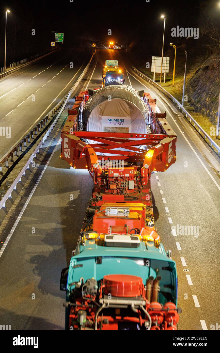 Hirwaun Power, Drax, transportierte ein 700 Tonnen schweres Lastkraftfahrzeug zusammen mit einer Polizeieskorte auf der A456 in der Nähe von Llanelli Hill als Teil der Arbeiten zum Bau eines neuen Gaskraftwerks, des Kraftwerks, das einmal in Betrieb war, kann bis zu 1.500 Stunden in einem beliebigen Jahr laufen. Sie wird als Reserve für andere Stromquellen dienen, darunter wetterabhängige Windturbinen und Solarparks, Llanelli Hill, Vereinigtes Königreich, 15. Januar 2024 Link to Hirwaun Power; https://www.drax.com/about-us/our-projects/hirwaun-power/#frequently-asked-questions-faqs (Foto: Thomas Winstone/News Images) in Llan Stockfoto