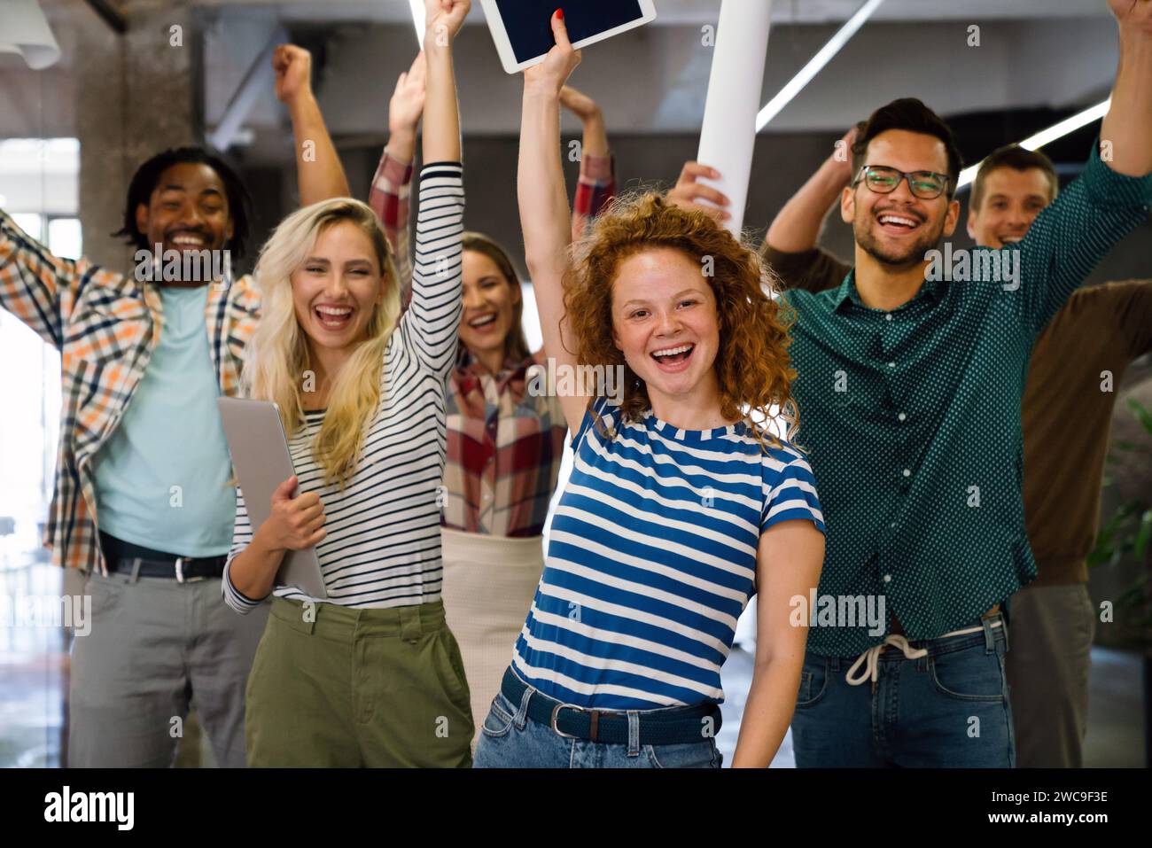 Glückliches Team verschiedener Mitarbeiter, das Erfolg und Geschäftserfolg feiert Stockfoto