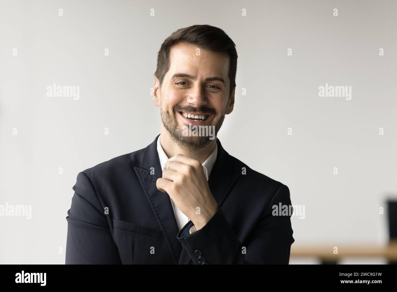 Fröhlicher, gutaussehender Geschäftsmann, der in die Kamera schaut Stockfoto