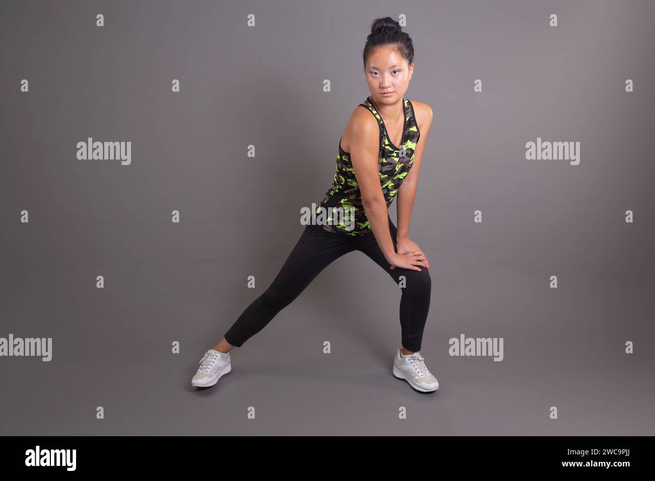 Junge asiatische Frau, die eine aktive Fitness-Haltung hat Stockfoto
