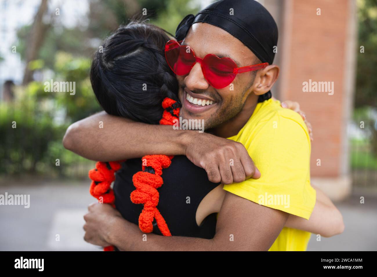 Intime Nahaufnahme von zwei Tänzern, die eine fröhliche Umarmung teilen, mit Ausdrücken von Glück und Zufriedenheit nach einem Tanz. Stockfoto