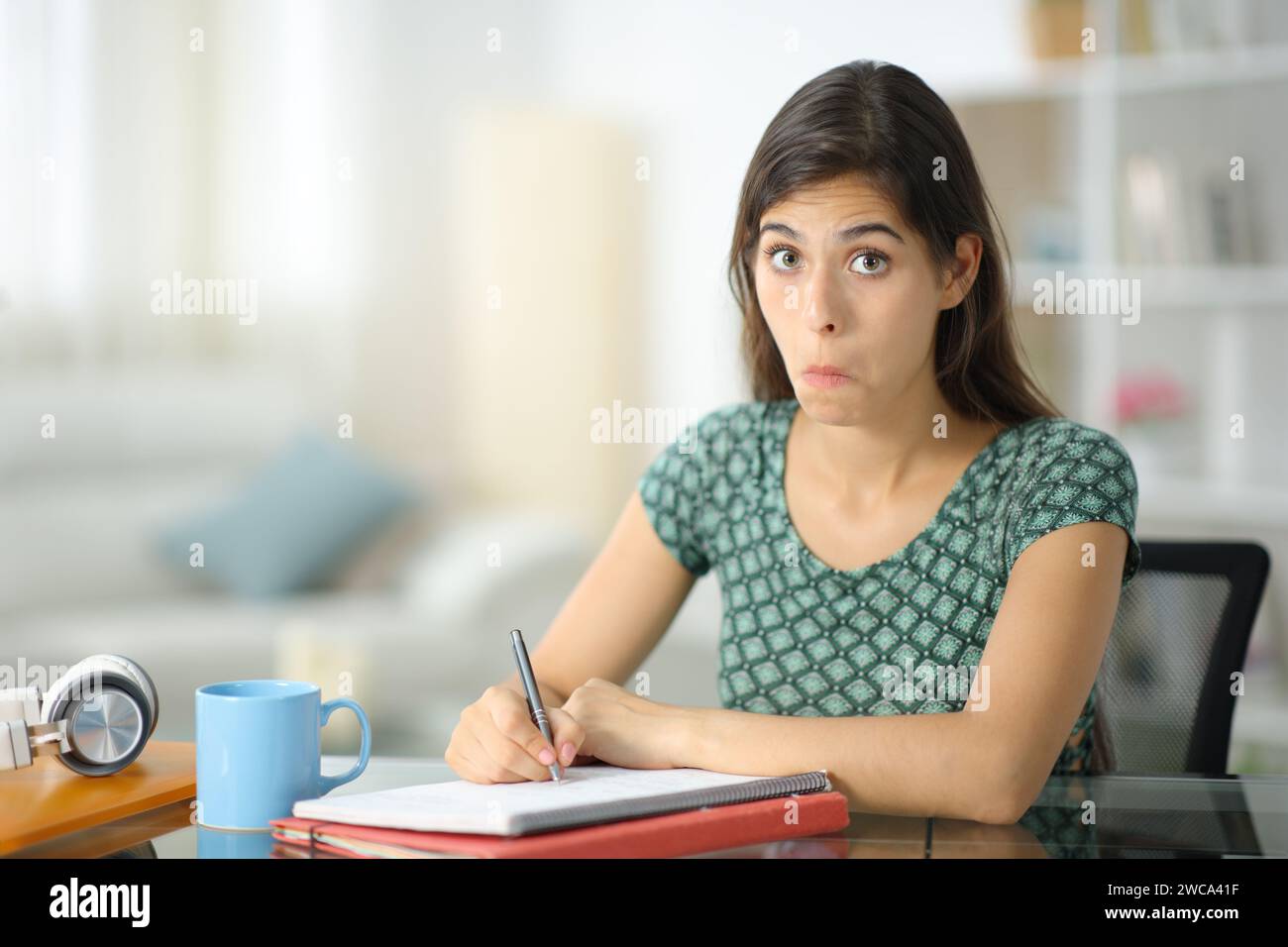 Verwirrter Student, der zu Hause in die Kamera schaut Stockfoto