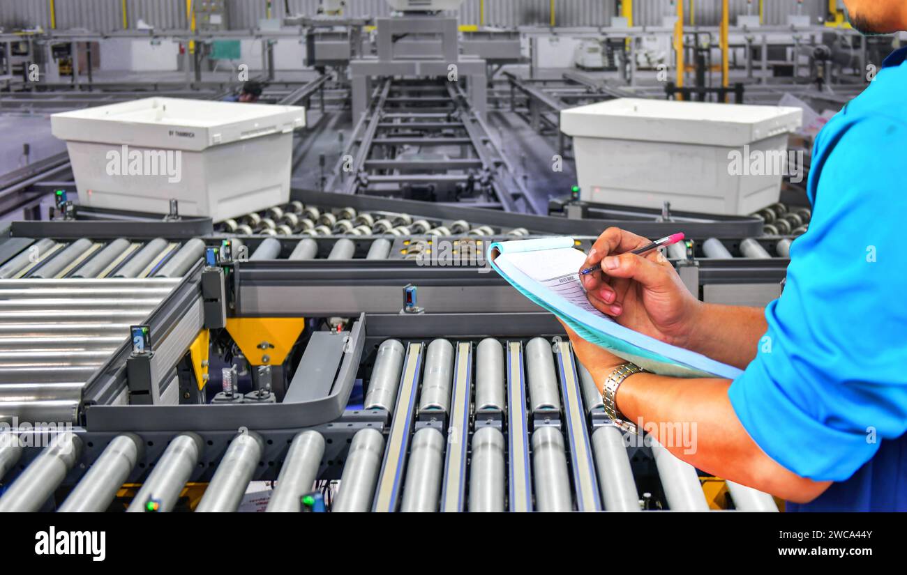 Der Manager prüft die Anzahl der Kartons auf dem Transportsystem „Transportband.Parcels“ Stockfoto