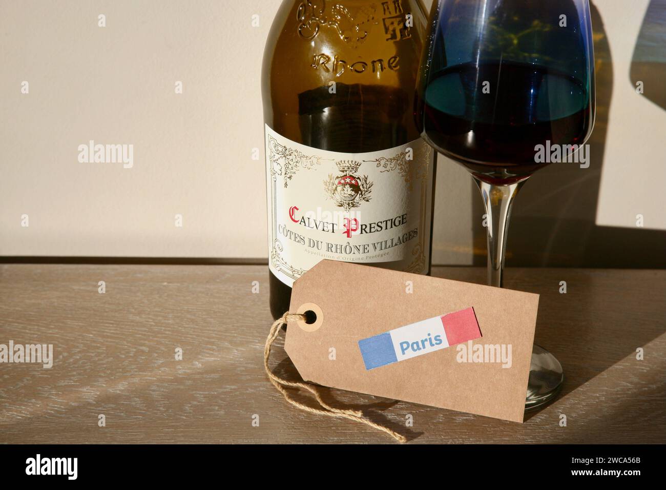 Eine Flasche französischer Wein, ein Glas Rotwein und ein Gepäcketikett für den Weg in die französische Hauptstadt Paris Stockfoto