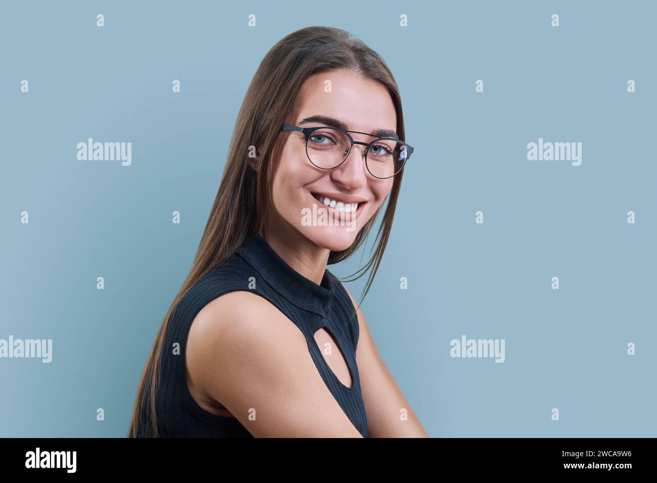 Kopfbild-Porträt einer jungen Frau in trendiger Brille auf grauem Hintergrund Stockfoto