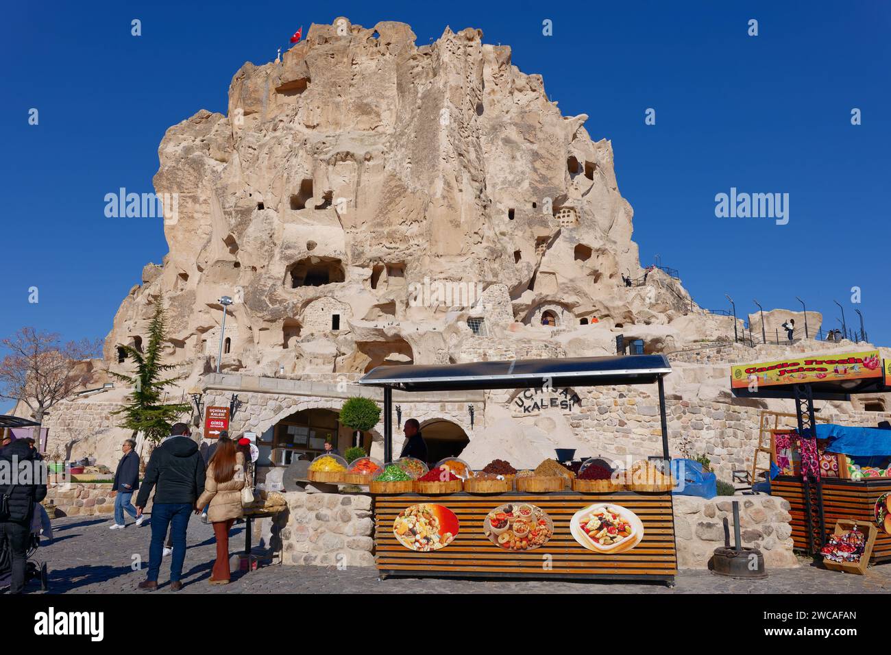 Schloss Uchisar in Kappadokien, Türkei. Vorbeiziehende Leute und Verkäufer, die Süßigkeiten und Früchte verkaufen. Stockfoto