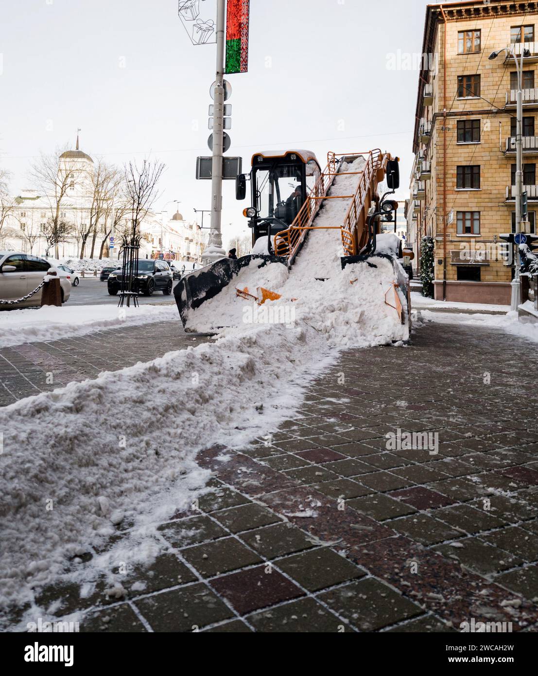 Reinigung des Gehwegs im Winter nach Schneefall. Kommunale Dienstleistungen Stockfoto