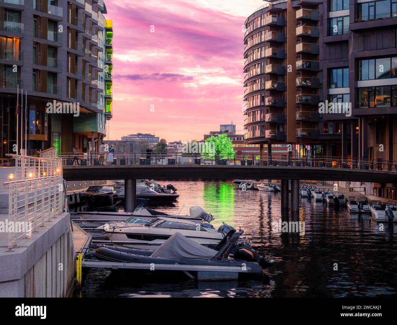 Kanal mit verankerten Booten im Aker Brygge Viertel in Oslo, Norwegen. Typisches Beispiel skandinavischer Architektur im Aker Brygge-Viertel in Oslo Stockfoto