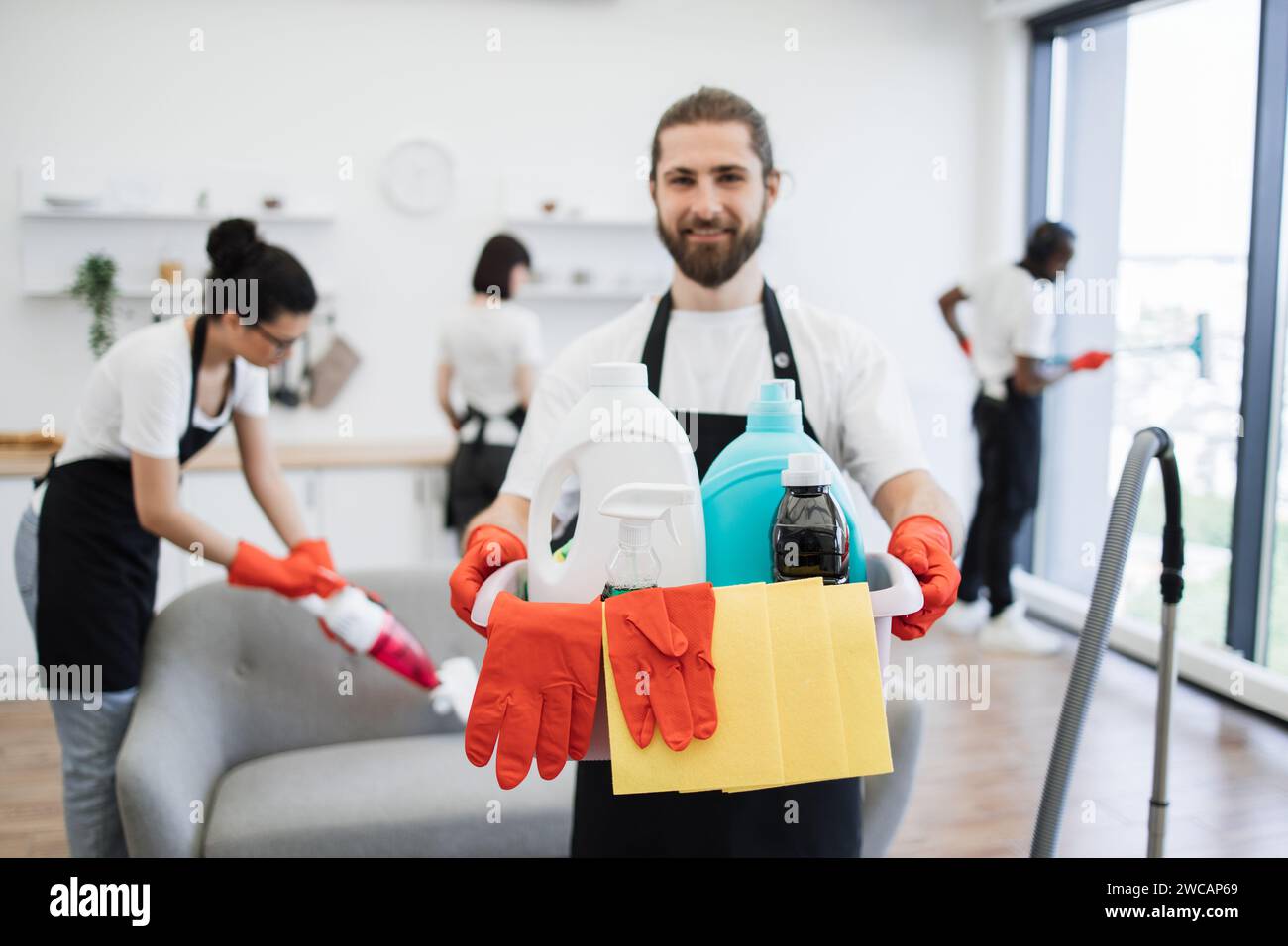 Konzentrieren Sie sich auf den Eimer mit Reinigungsmitteln in den Händen eines Kaukasiers Stockfoto