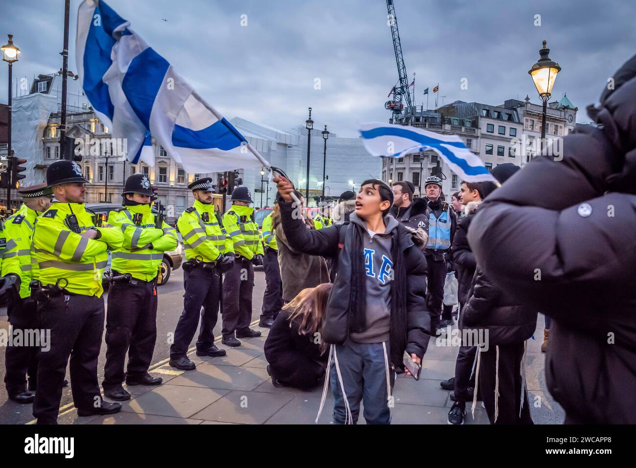 Jüdische Teenager, die auf der Pro-Israel-Kundgebung auf dem Trafalgar-Platz auf Fahnen vor der Polizeilinie verzichten und die Freilassung von Geiseln fordern und 100 Tage si markieren Stockfoto