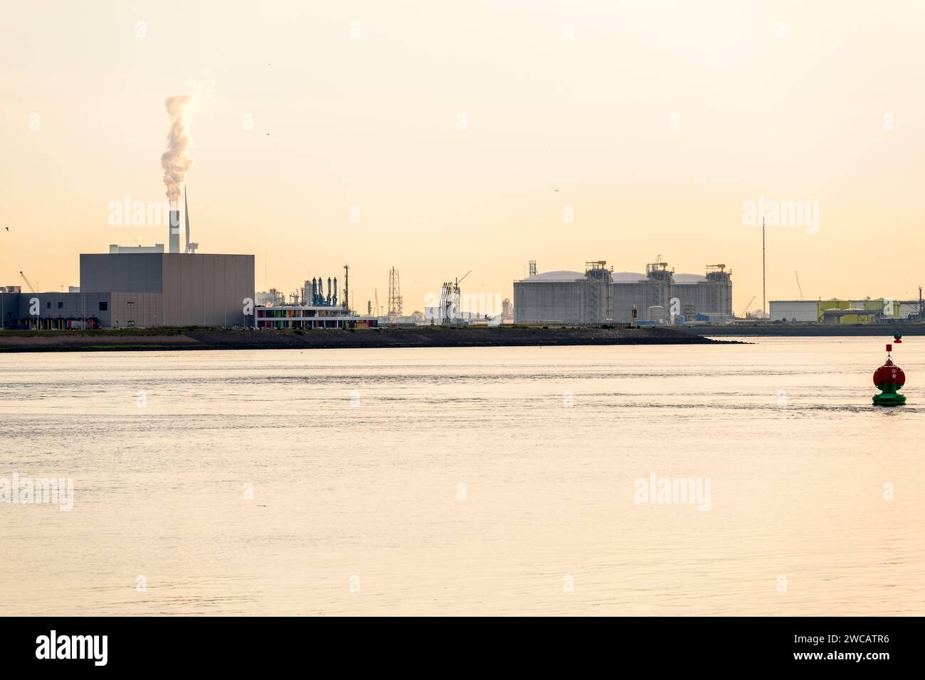 Industrieanlagen und Brennstofflagertanks an den Kais eines großen Seehafens bei Sonnenuntergang Stockfoto