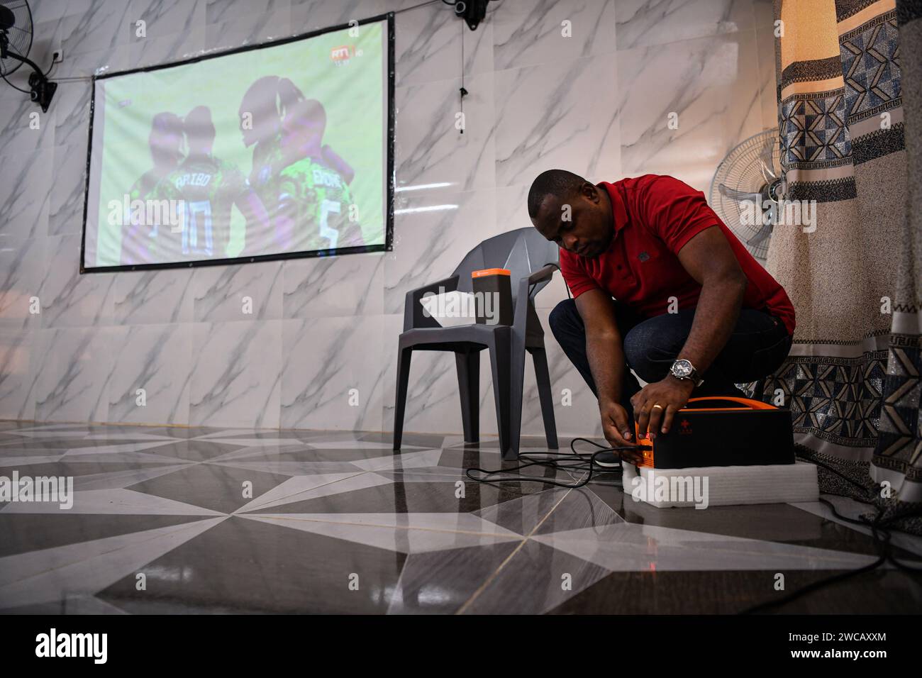 (240115) -- ABIDJAN, 15. Januar 2024 (Xinhua) -- Ein Techniker spielt Satelliten-TV-Ausrüstung in Yaou Village, Cote d'Ivoire, 14. Januar 2024. Tausende von Menschen, die in abgelegenen Gebieten in der Elfenbeinküste und anderen afrikanischen Ländern lebten, konnten die Spiele zu Hause anschauen, als am Samstag der Afrikacup der Nationen (AFCON) 2023 begann, dank der Sendedienste von StarTimes, einem chinesischen Digital-TV-Betreiber. Ein Projekt, das 10.000 afrikanische Dörfer mit Satellitenfernsehdiensten verbinden soll, wurde während des Gipfels des Forums zur Zusammenarbeit zwischen China und Afrika (FOCAC) in Johannesburg (Süd-AFR) vorgeschlagen Stockfoto