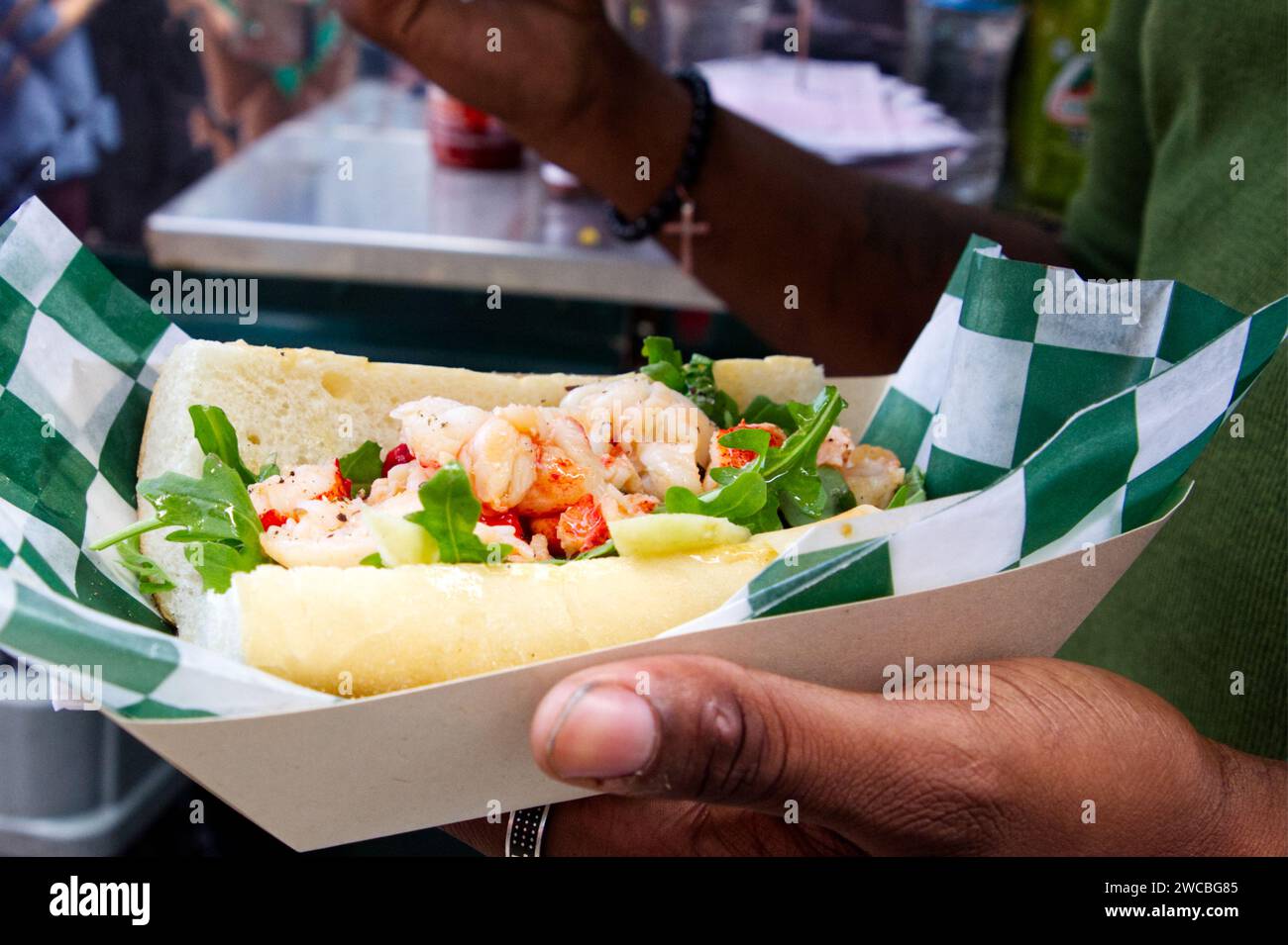 Ein köstliches Garnelensandwich, das bei einem Food Truck Festival gekauft wurde, ist nur wenige Sekunden vom Verzehr entfernt. Stockfoto