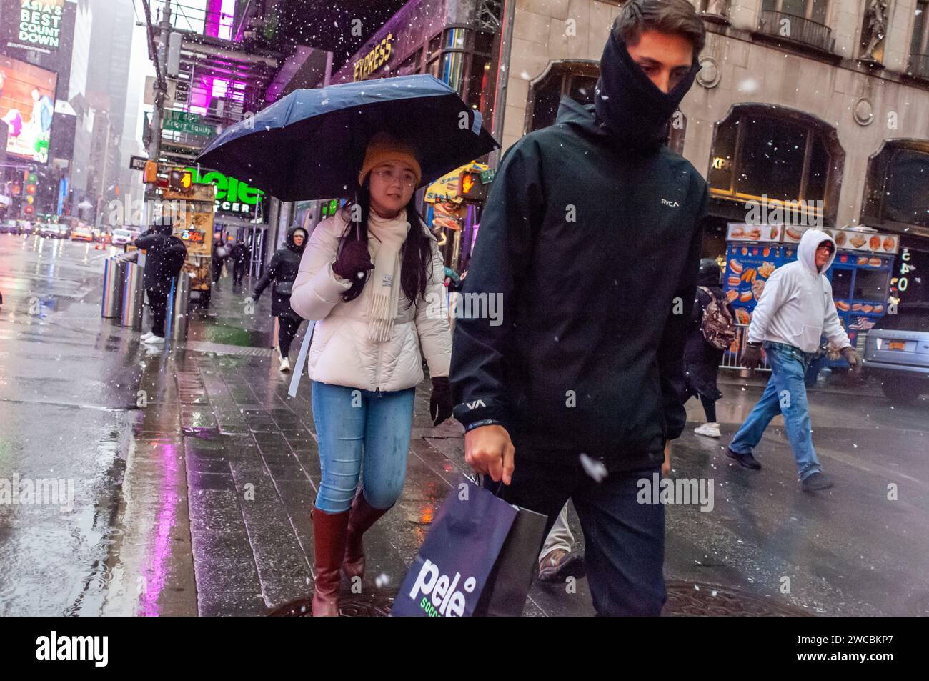 Besucher des Times Square am Sonntag, den 7. Januar 2024, kämpfen mit Schnee, Regen und Schneeregen vom Ende eines Wintersturms. © Richard B. Levine) Stockfoto
