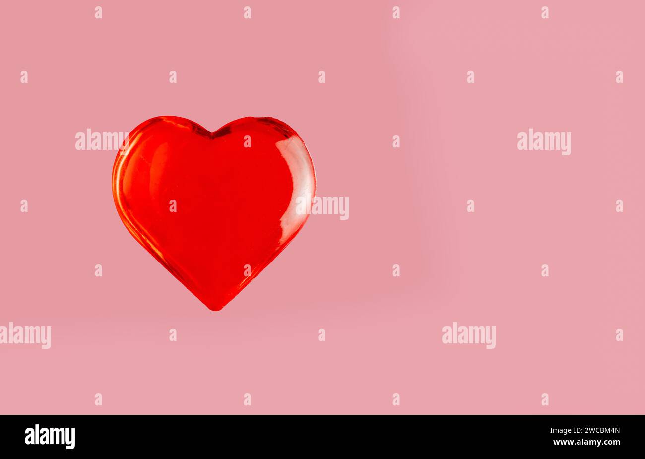 Valentinstag rotes Herz isoliert auf einem sanften rosa Hintergrund Stockfoto