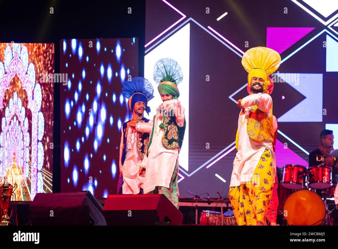 Gruppe von punjabi-Künstlern aus punjab, die Bhangra-Tanz in traditionellen bunten Kleidern beim bikaner Kamelfestival mit Lächeln und Spaß aufführen. Stockfoto