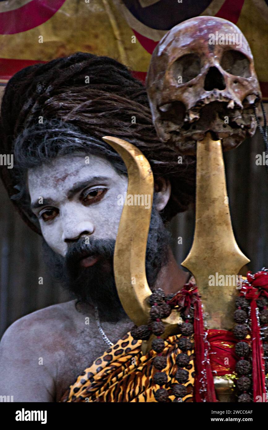 Ein indischer Mönch mit einem Trishul und einem menschlichen Schädel bei einem großen und beliebten indischen spirituellen Anlass, der nach „Makar Sankranti“/„Ganga Sagar Mela“ benannt wurde Stockfoto