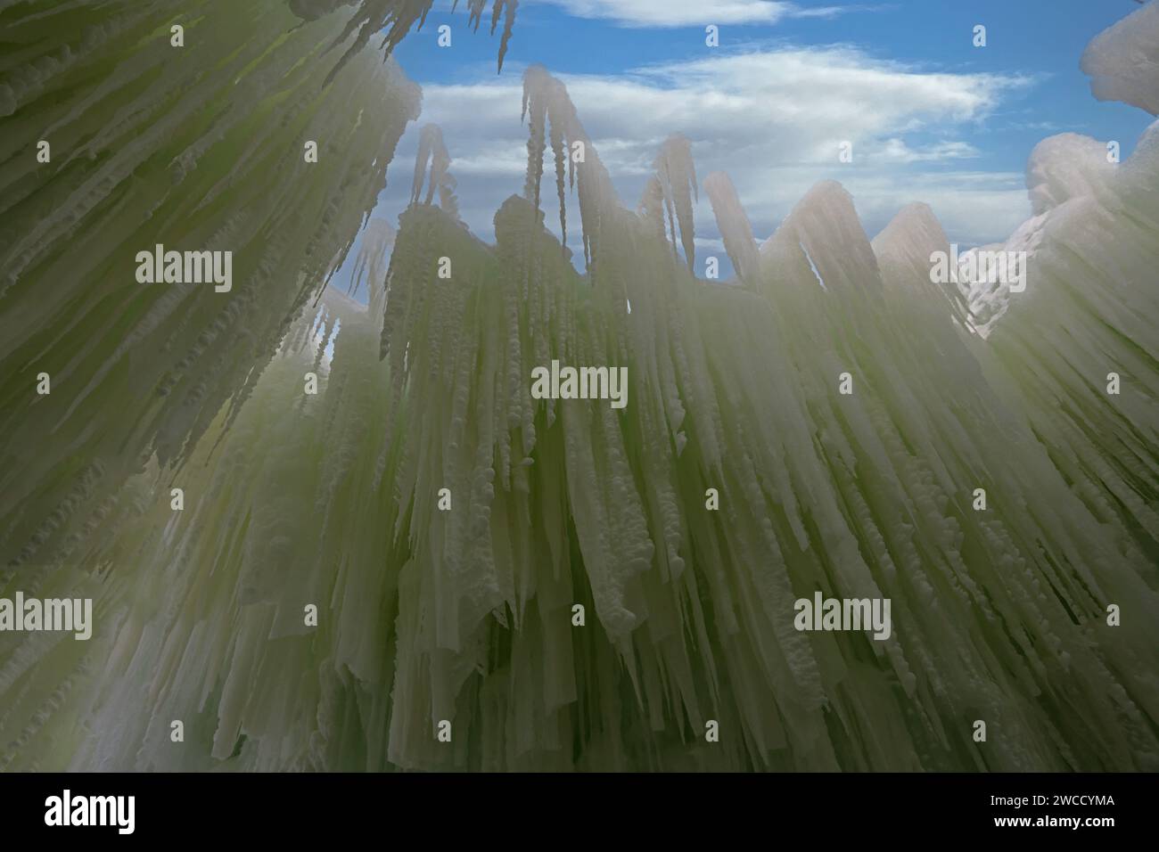 Blick auf eine hoch aufragende Eiszapfwand, die von hinten von grünen Lichtern beleuchtet wird, in Ice Castles am Genfer See, Wisconsin, USA Stockfoto