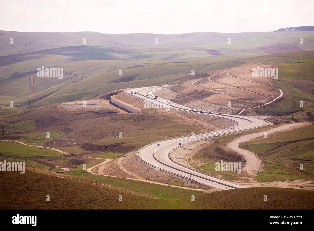 Shemakha. Aserbaidschan. 03.26.2021. Neue gewundene Shemakha-Straße zwischen den Hügeln. Stockfoto