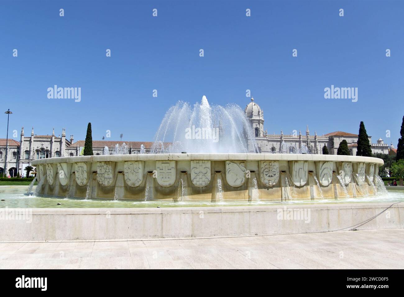 Hinter dem Brunnen im Jardim da Praca do Império, einem Garten in Lissabon. Das Kloster Jerónimos oder Hieronymitenkloster ist ein ehemaliges Kloster des Ordens des Heiligen Jerome in der Nähe des Flusses Tejo in der Pfarrei Belém in der portugiesischen Gemeinde Lissabon. Sie wurde im 16. Jahrhundert zur Nekropole der portugiesischen Königsdynastie Aviz, wurde aber am 28. Dezember 1833 durch einen staatlichen Erlass säkularisiert und das Eigentum an die gemeinnützige Institution Real Casa Pia de Lisboa übertragen. Stockfoto