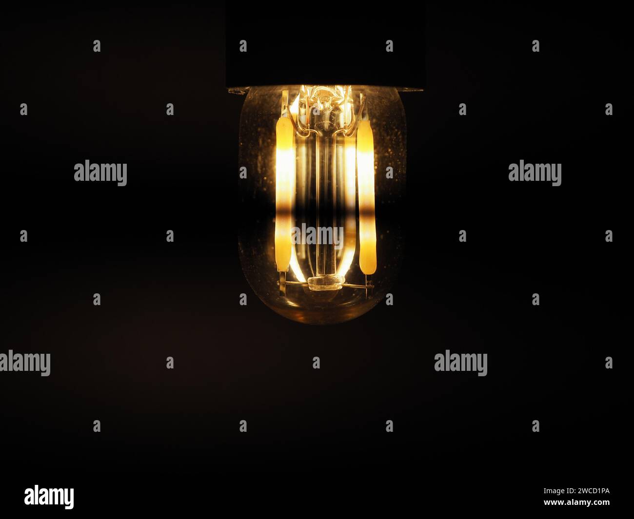 Billige LED-Glühlampe flackert über dunklem Hintergrund Stockfoto