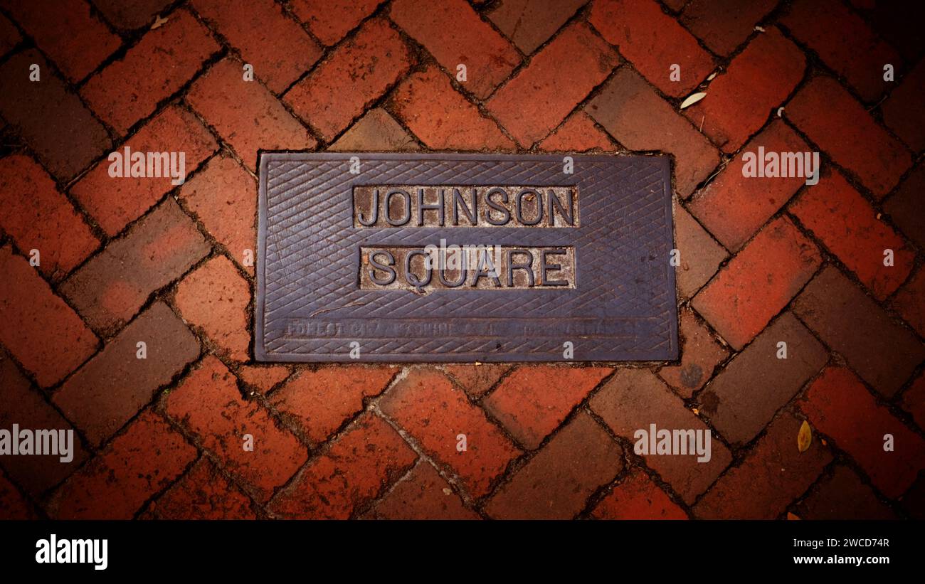 Johnson Square Namensschild auf einem gemauerten Gehweg auf dem ältesten und größten Platz in Savannah, Georgia; gelegen an der Bull Street und St. Julian Street. Stockfoto