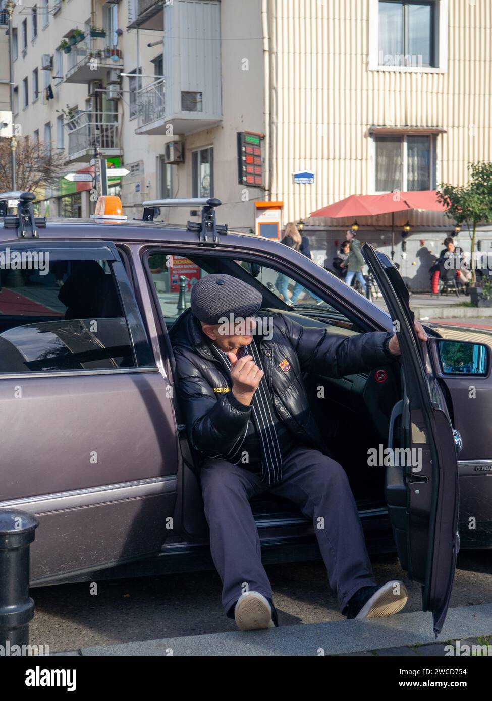 Batumi, Georgien. 01.07.2024 ein alter Taxifahrer sitzt und wartet auf Befehle. Taxi hat keine Gäste. Ein alter Taxifahrer Stockfoto
