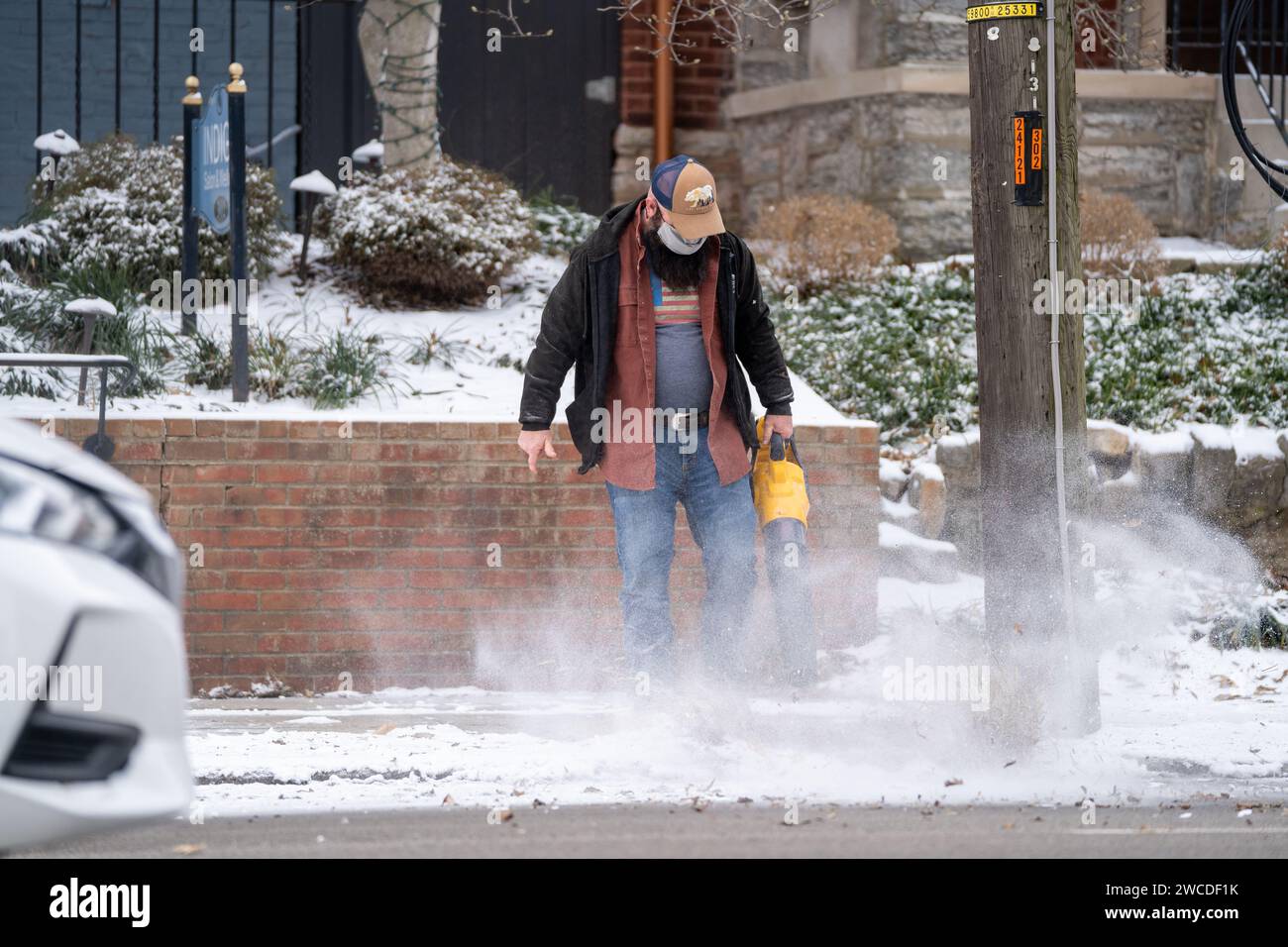 Eine Person bläst Schnee vom Gehweg am Montag, 15. Januar 2024 Stockfoto