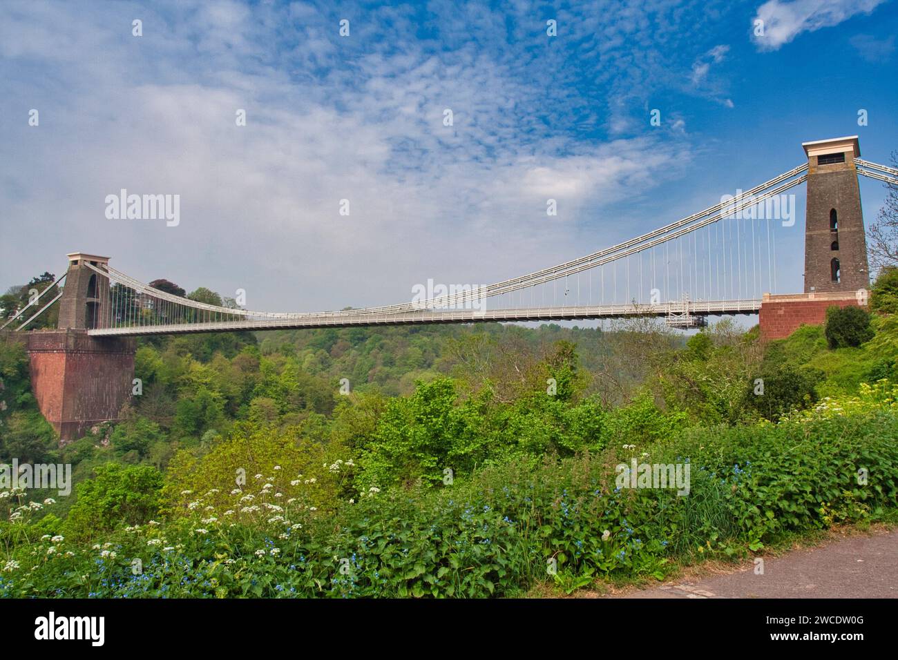 Dieses Bild zeigt eine malerische Brücke über einem ruhigen Fluss, umgeben von majestätischen hohen Türmen Stockfoto