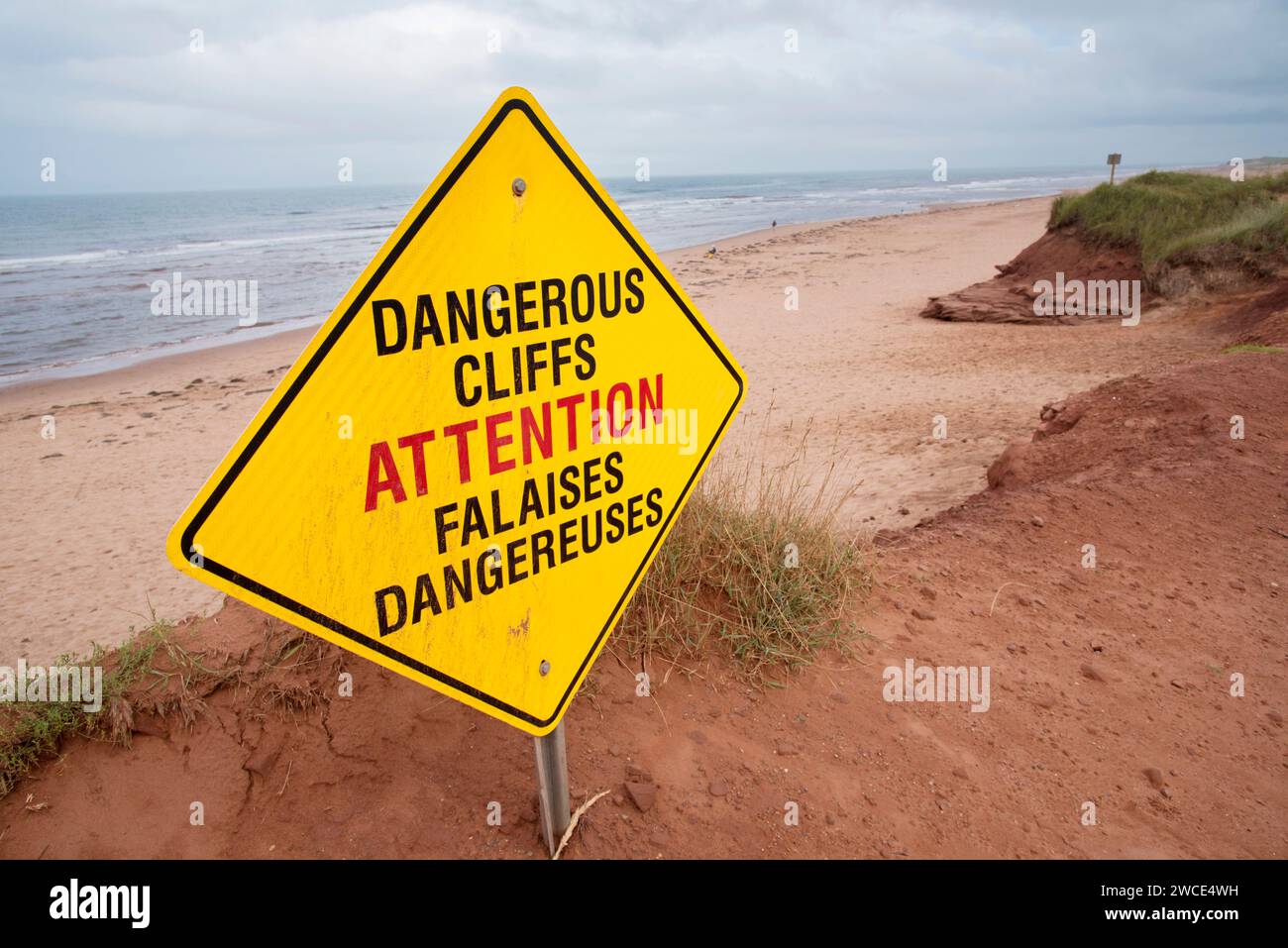 Zweisprachiges gelbes Zeichen, das Menschen vor gefährlichen erodierenden Klippen in Darnley, Prince Edward Island, Kanada warnt Stockfoto