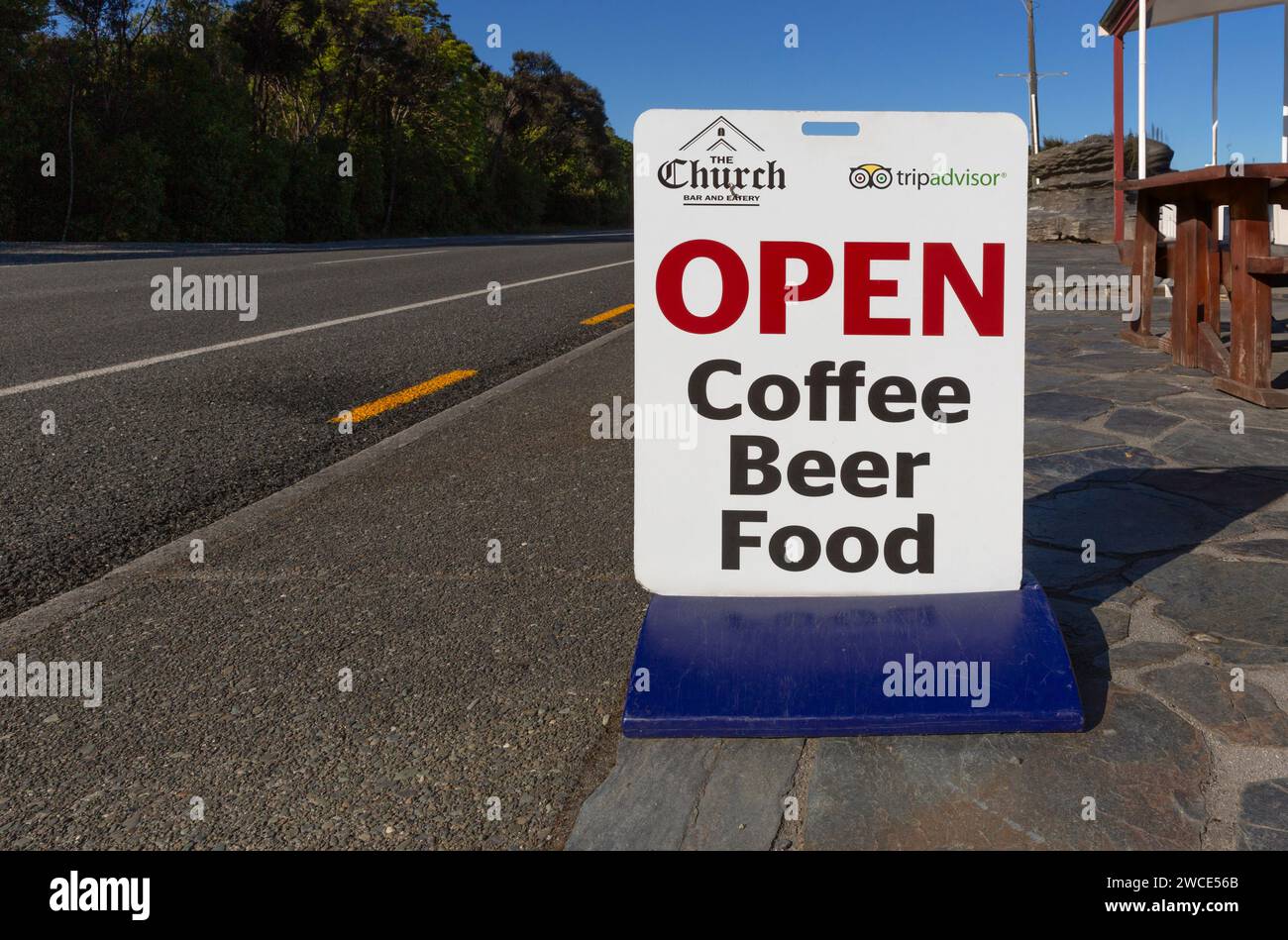 Straßenschild für die Kirche Bar und das Restaurant Werbung für Kaffee, Bier, Essen in Manapouri, Aotearoa (Neuseeland), Waipounamu (Südinsel) Stockfoto