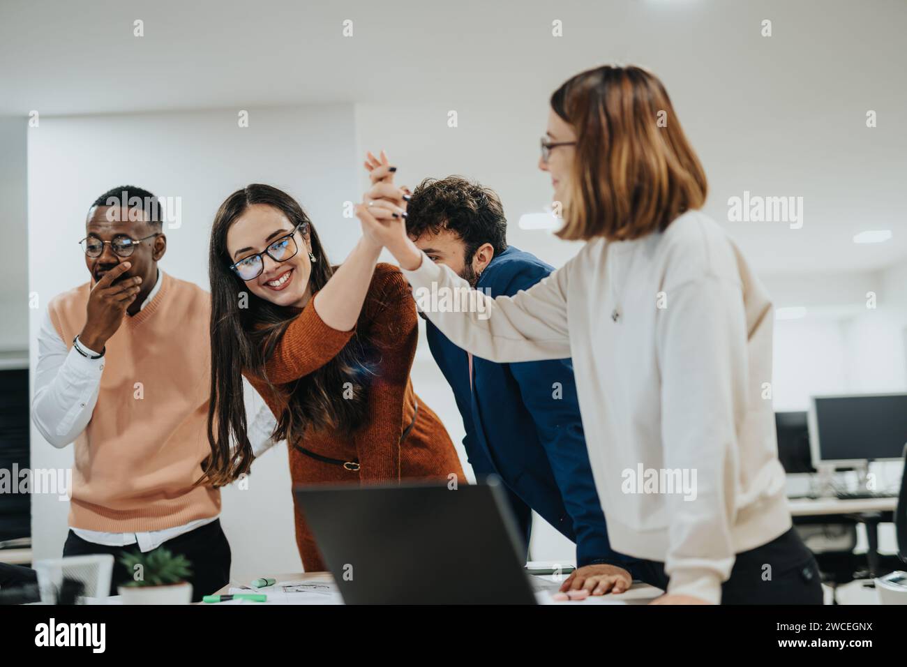 Multirassische Kollegen arbeiten spät in der Nacht in einem Kreativbüro zusammen Stockfoto
