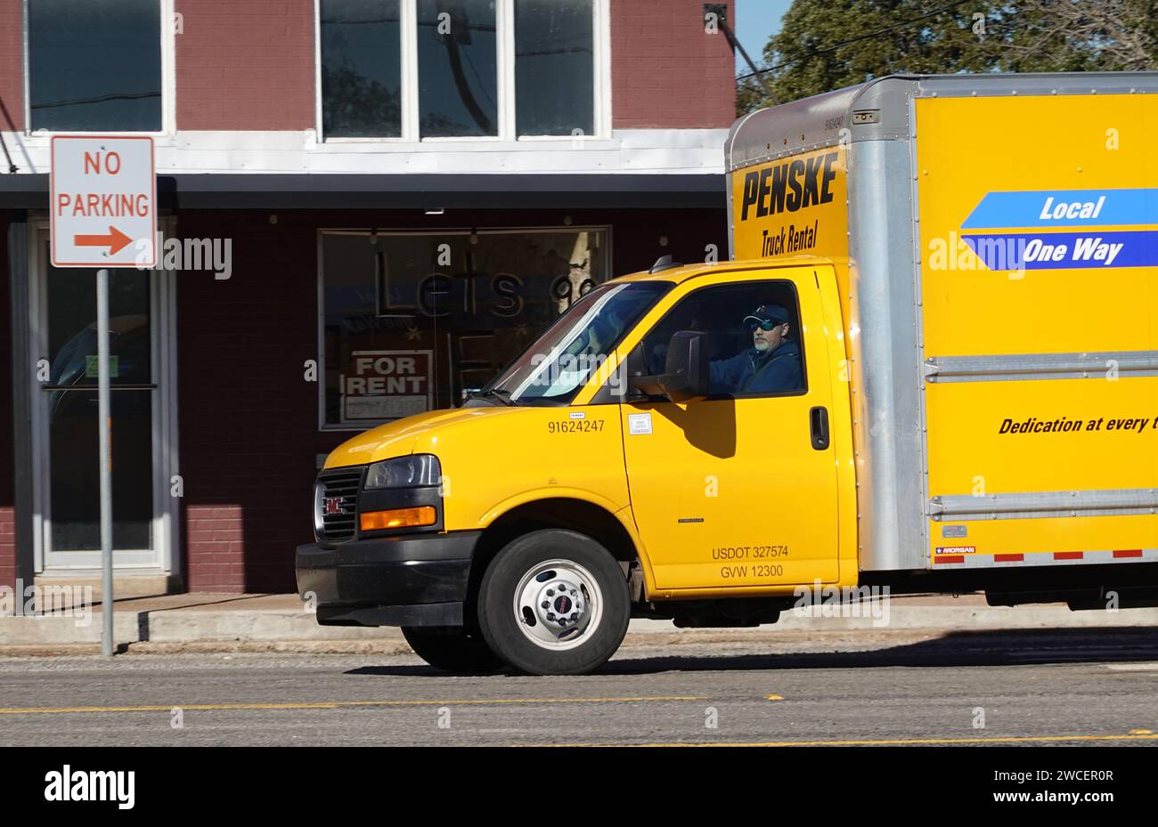 Gelber Penske fahrender Van, der auf einer Autobahn durch Evant Texas fährt - November 2023 Stockfoto