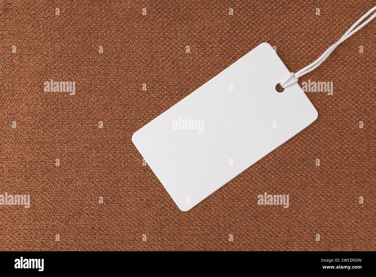 Textilinhalt, orange grobe Textur mit weißem leerem Bekleidungsanhänger, Jacquard gewebte Polsterung, Möbeltextil Material, Hintergrund, Mocku Stockfoto