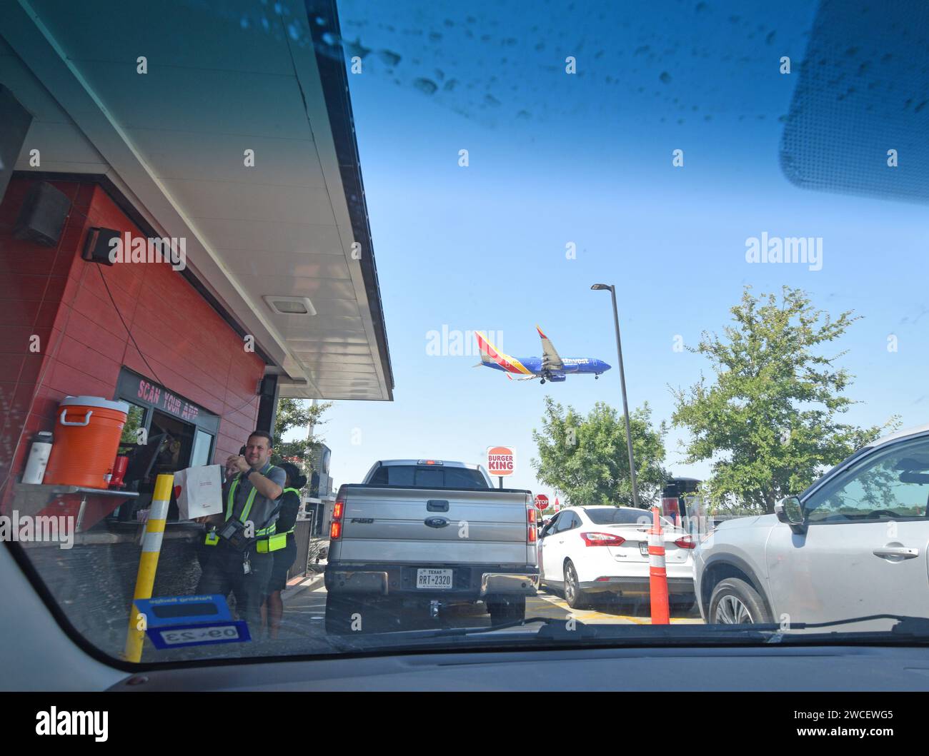 Arbeiter und Autos in einem Drive-Thru in einem Chick-Fil-A Restaurant in der Nähe von Love Field in Dallas, Texas - August 2023 Stockfoto