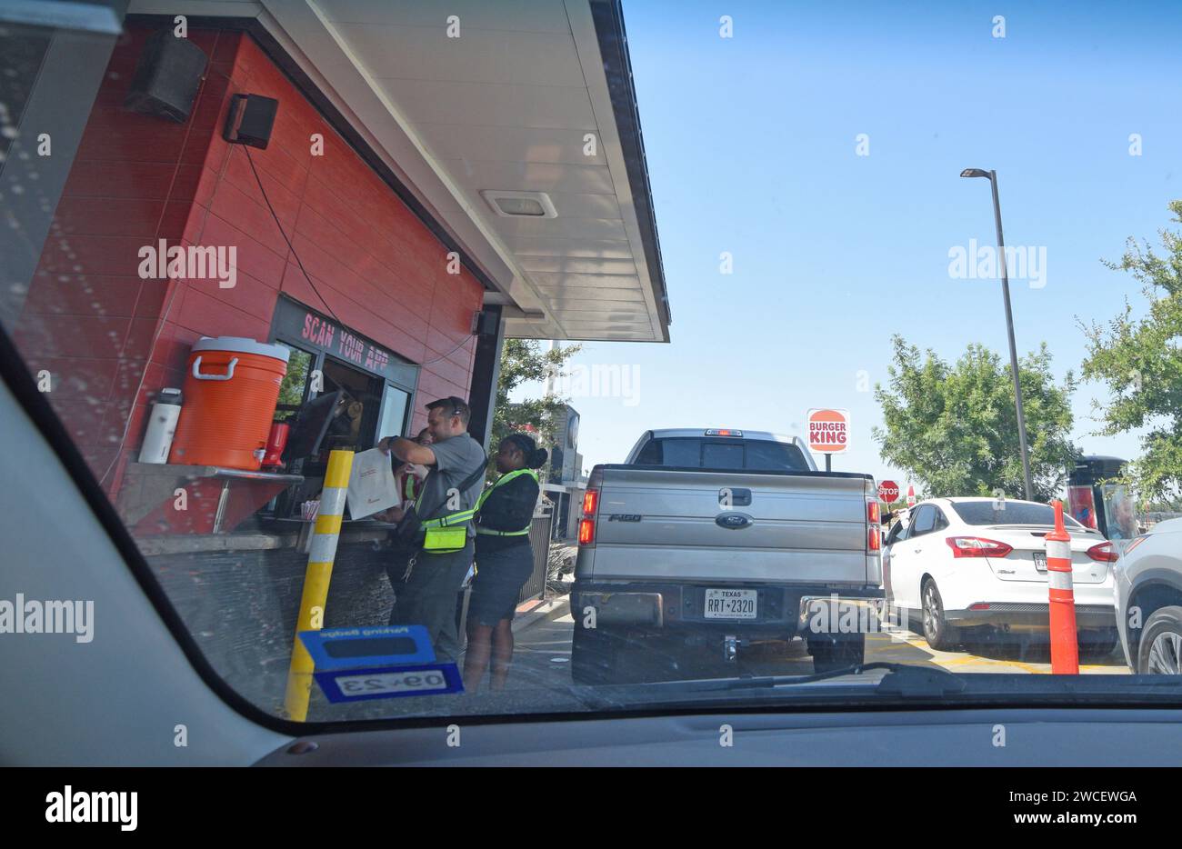 Arbeiter und Autos in einem Drive-Thru in einem Chick-Fil-A Restaurant in der Nähe von Love Field in Dallas, Texas - August 2023 Stockfoto