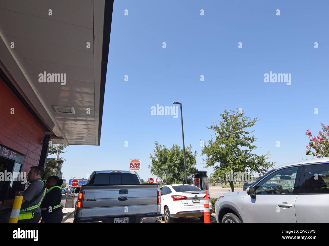 Arbeiter und Autos in einem Drive-Thru in einem Chick-Fil-A Restaurant in der Nähe von Love Field in Dallas, Texas - August 2023 Stockfoto