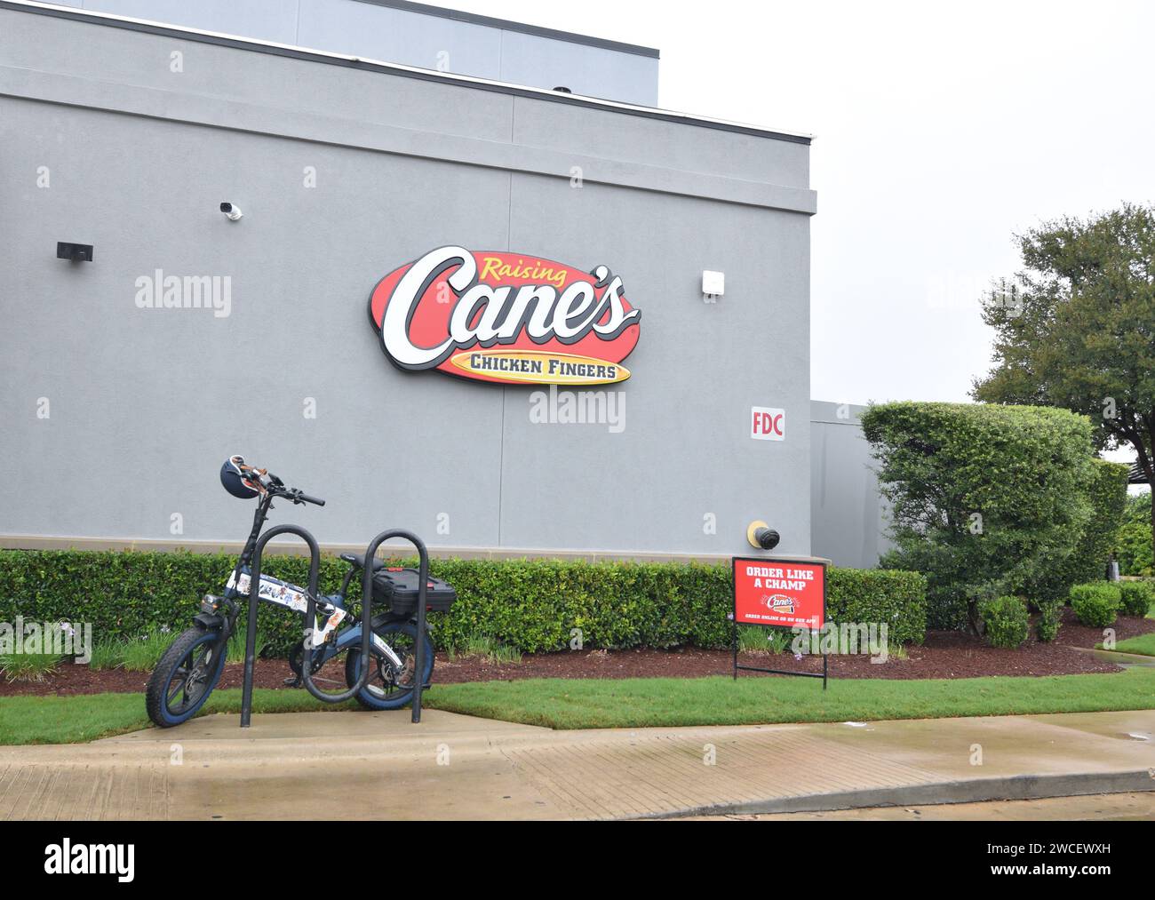 Elektroroller, der an einem bewölkten Tag in Georgetown, Texas, vor dem Fast-Food-Restaurant A Cane geparkt wurde - August 2023 Stockfoto