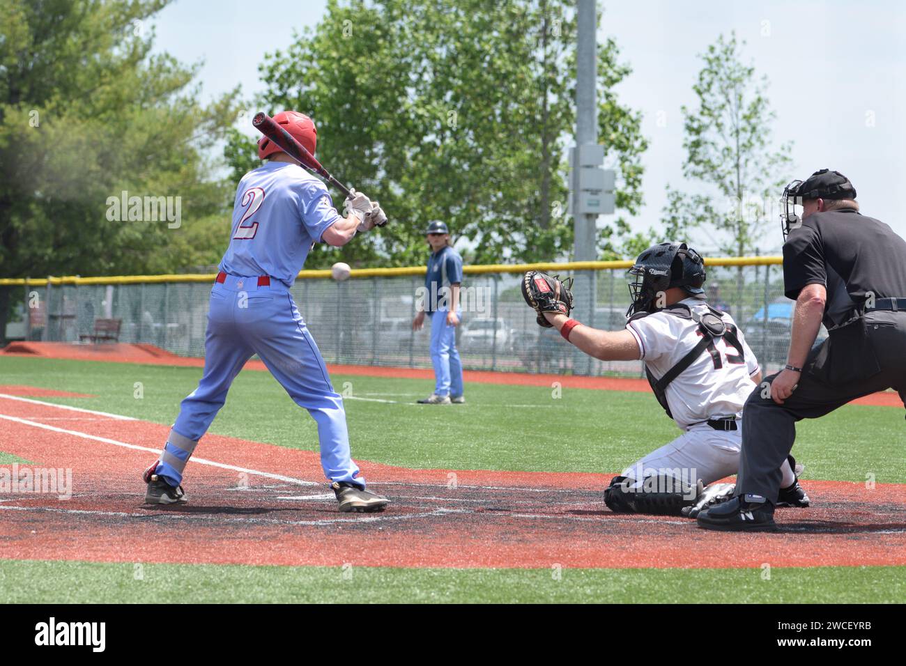 Ein College-Baseballspieler beim Schläger gegen das Dallas Christian College, der Ball fliegt am Schläger vorbei - Mai 2023 Stockfoto