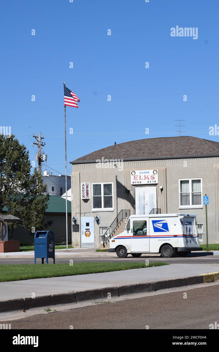 Akron Elks Lodge Gebäude mit amerikanischer Flagge im Wind, US-Postwagen im Vordergrund - Juni 2023 Stockfoto