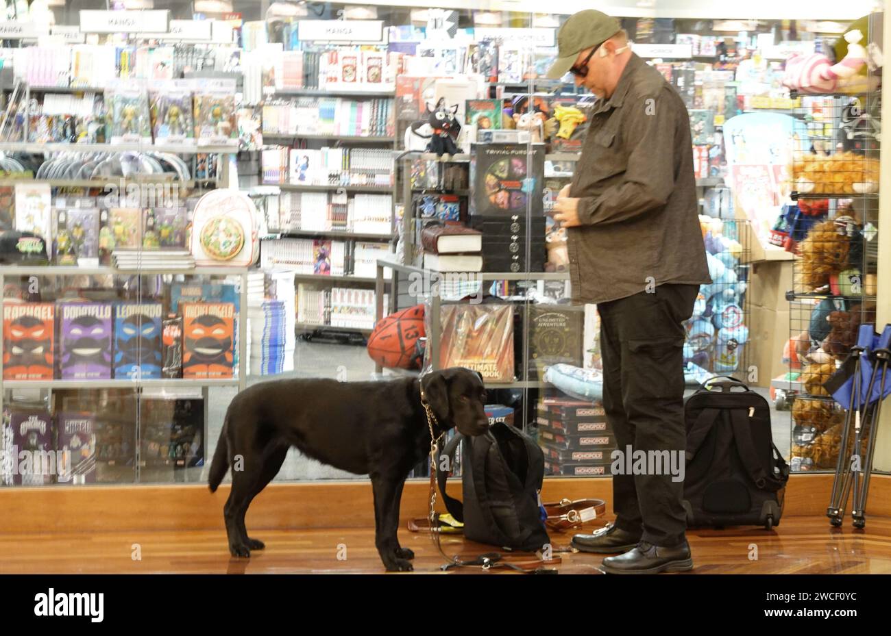 Ein Mann und sein Hund warten in der Schlange bei einer Dan Bongino Buchsignierveranstaltung - November 2023 Stockfoto