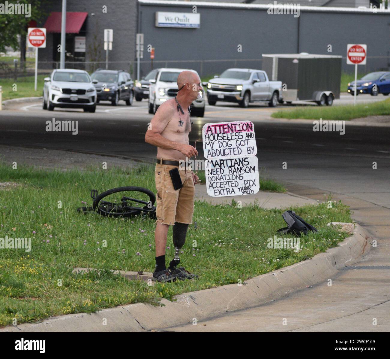 Obdachloser, der an einer Straßenecke in Springfield Missouri steht und ein Schild hält, in dem er um Lösegeldspenden für seinen Hund bittet, der von Martia entführt wurde Stockfoto