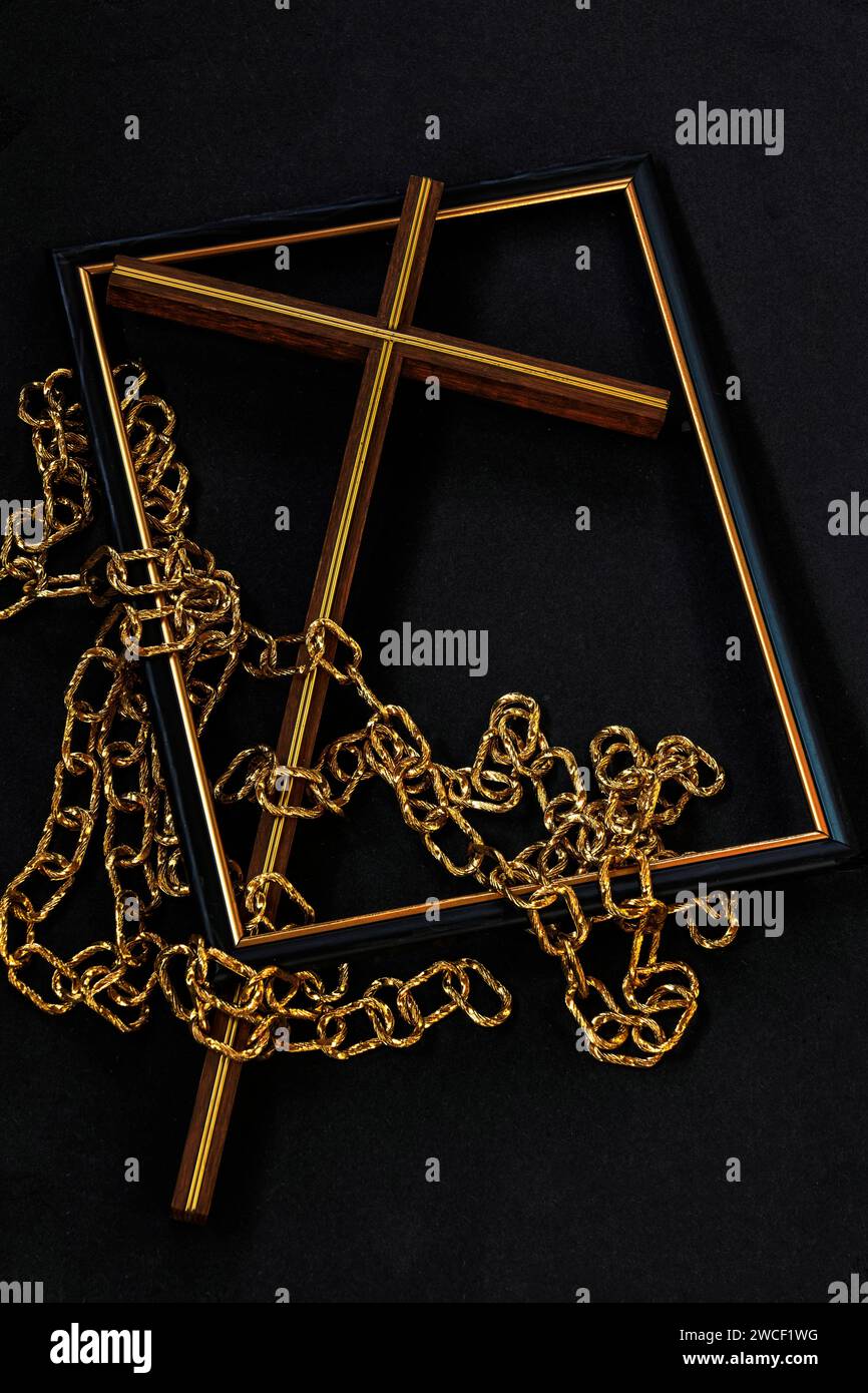 Die schwarze Anzeige zeigt einen Bilderrahmen mit christlichem Kreuz und goldenen Ketten, die das Heilskreuz und die gebrochenen Ketten von Sünde und Knechtschaft darstellen. Stockfoto